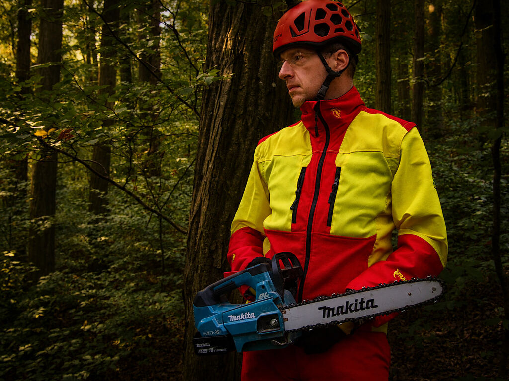 Arborista pripravený na výrub stromov s motorovou pílou a lezeckou prilbou, región Košice